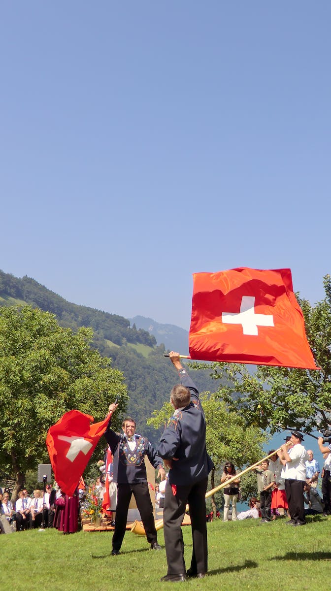 Celebration of Swiss heritage with participants waving flags in a vibrant outdoor setting.